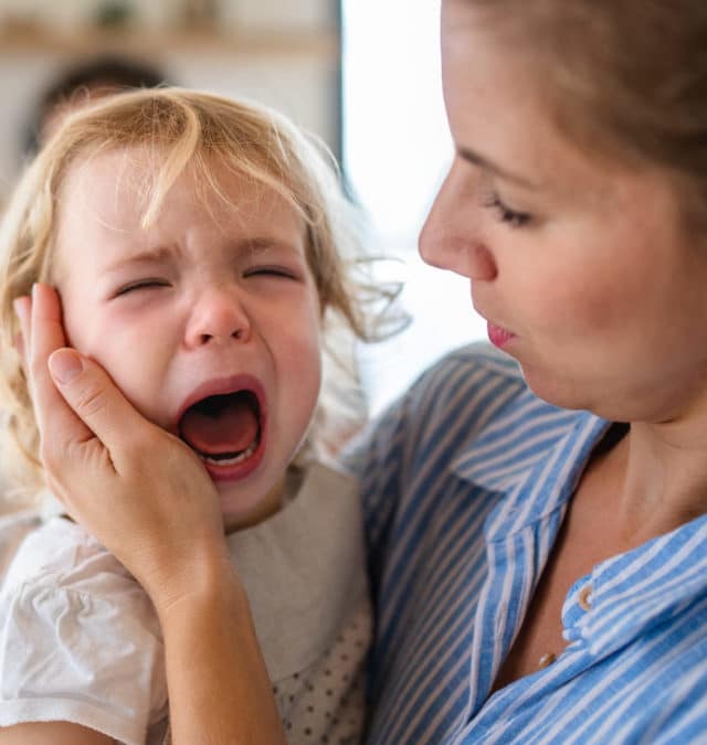 cropped-a-mother-holding-a-crying-toddler-daughter-indoors-2021-08-27-17-56-06-utc-scaled-1.jpg