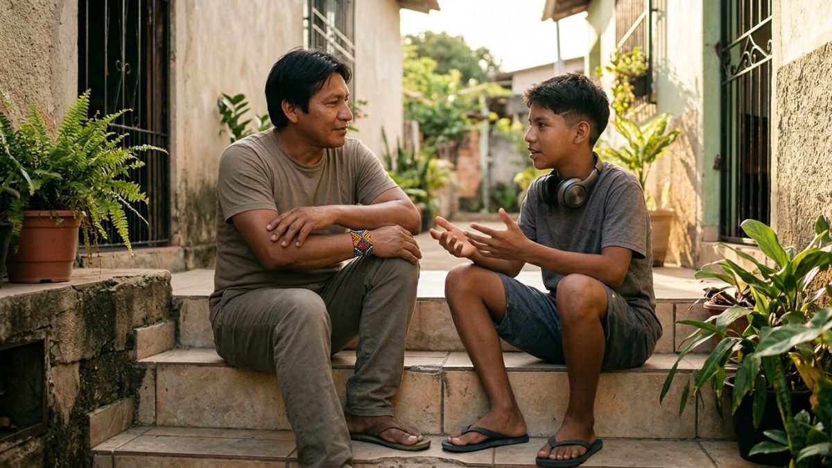 Pai e filho adolescente de uns 15 anos conversando sentados na escada de casa, o garoto com fone no pescoço e o pai escutando