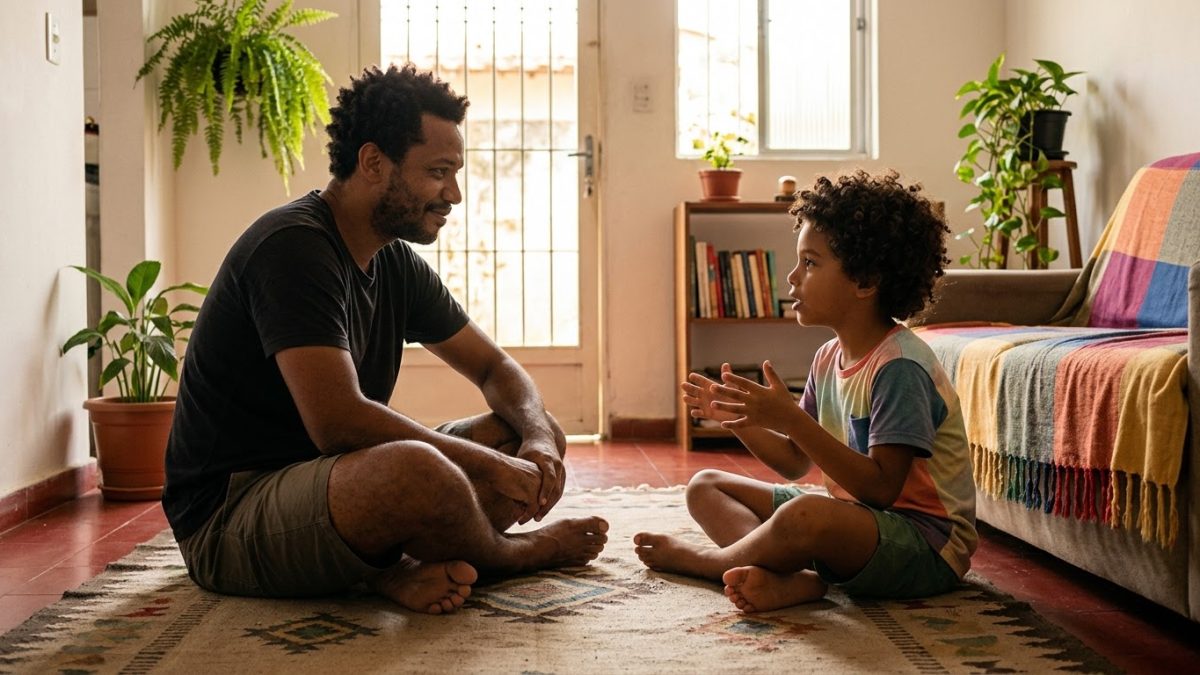 Pai e filho de 7 anos sentados frente a frente no tapete, conversando com calma